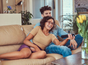 jovem casal vendo tv no sofá